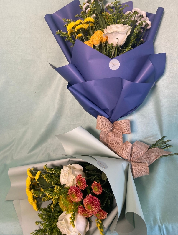 Bunch of flowers including seasonal stems, wrap and a ribbon.